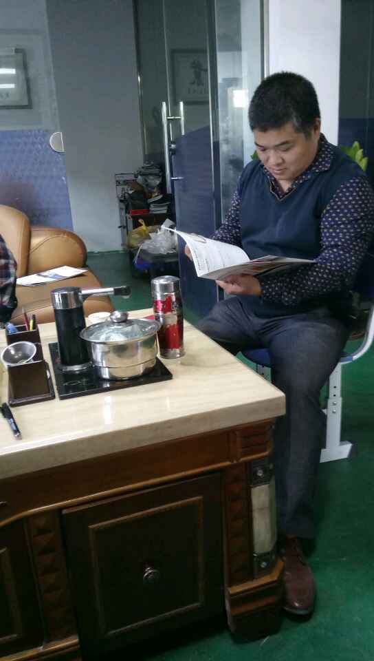 南海（hǎi）陳祥明老板想（xiǎng）買凱恩利46車先銑機——在邊聽業務代表講（jiǎng）解產品（pǐn）特（tè）點優點邊看宣傳書。